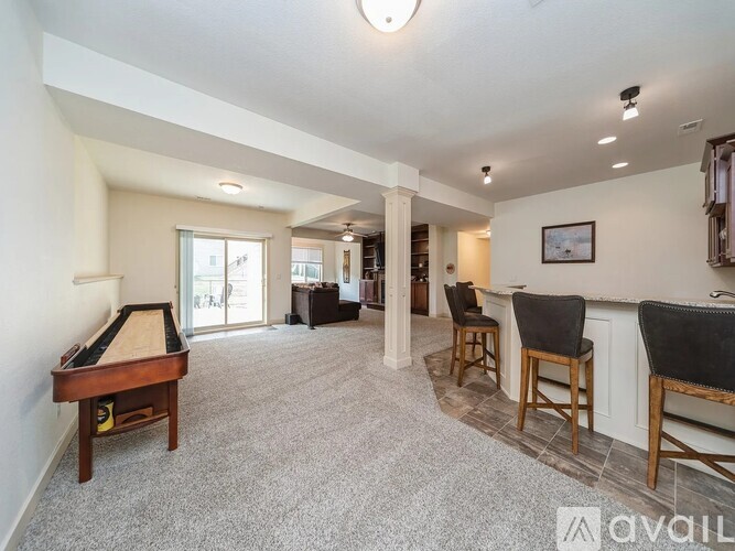 A room with a pool table and a bar area.