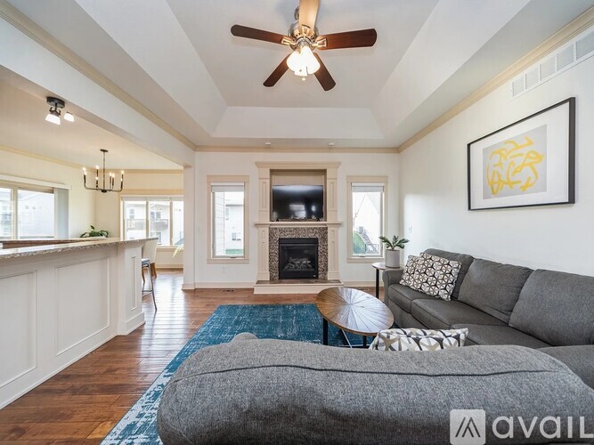 A living room with a grey couch and a fireplace.