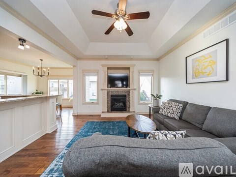 A living room with a grey couch and a fireplace.