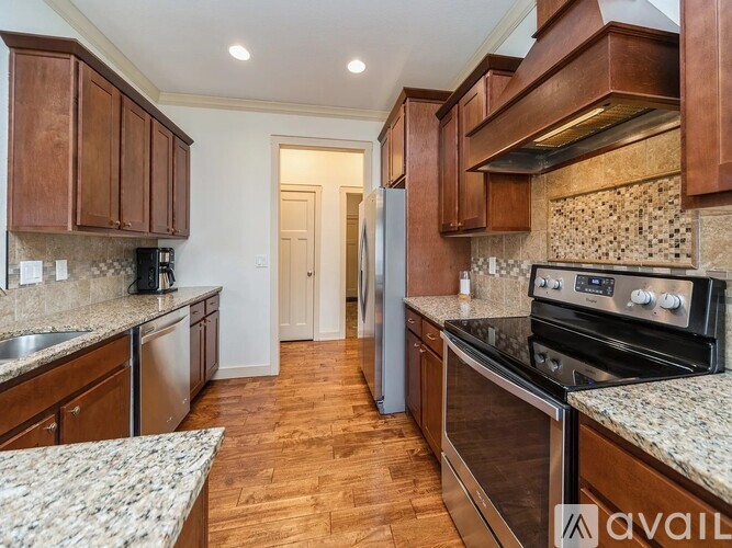 A kitchen with wooden cabinets and a granite countertop.
