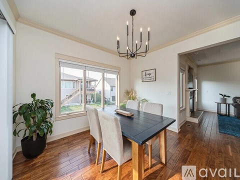 A dining room with a wooden table and chairs.
