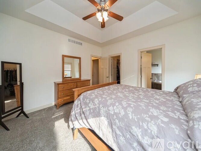 A bedroom with a large bed and a ceiling fan.