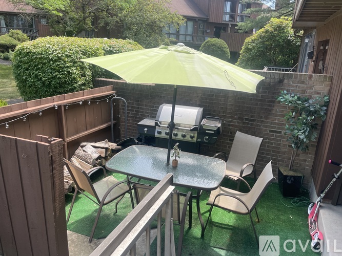 A patio with a table, chairs, and an umbrella.