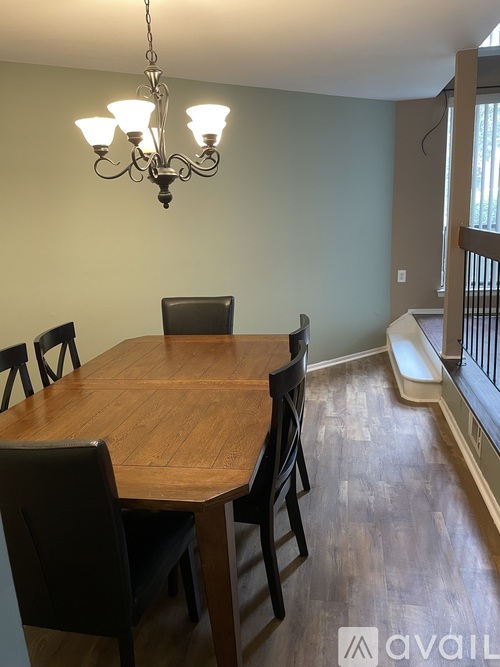 A dining room with a wooden table and chairs.
