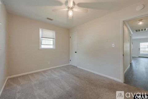 A room with a ceiling fan and a window.