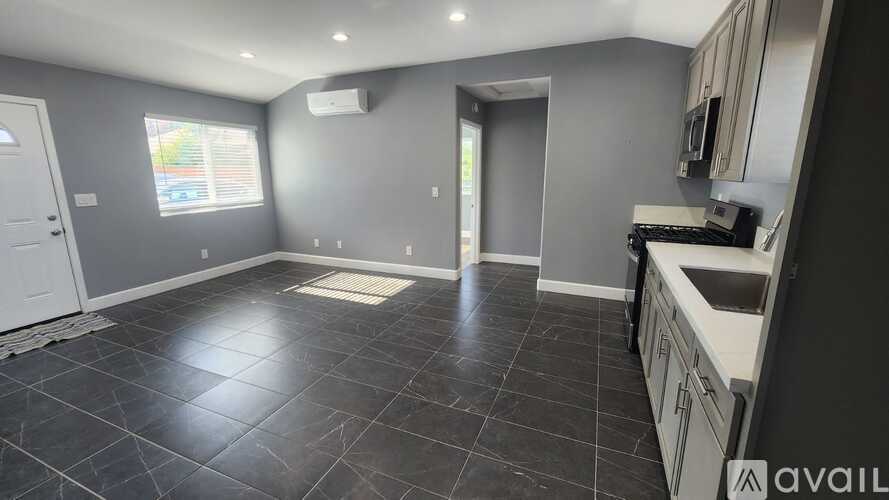 A kitchen with black tiles on the floor and a white door.