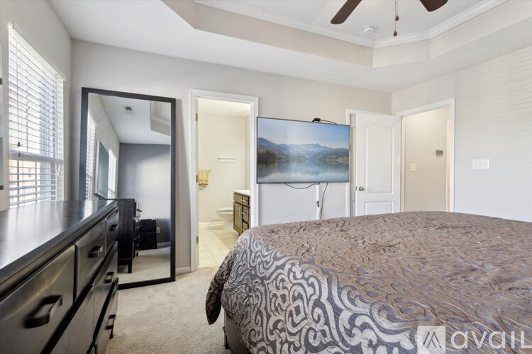 A bedroom with a large bed and a painting on the wall.