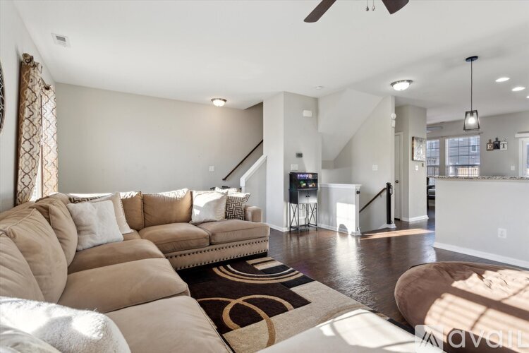 A living room with a brown sofa and a black and white rug.