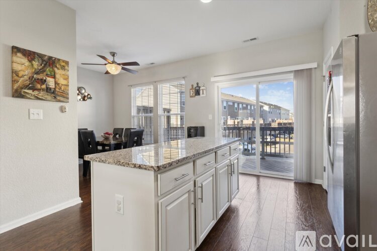 A kitchen with white cabinets and a marble countertop.