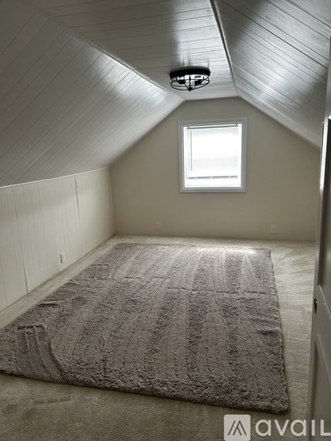 A bedroom with a bed and a window.