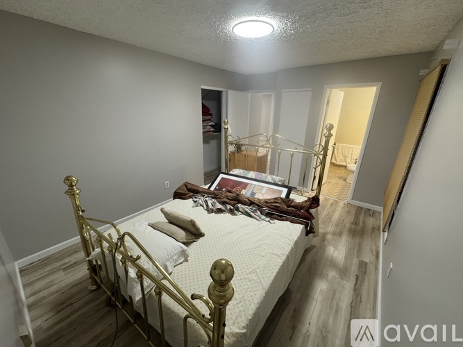 A bedroom with a bed and a dresser in the corner.
