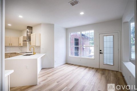 A kitchen with white cabinets and a white island with a sink.