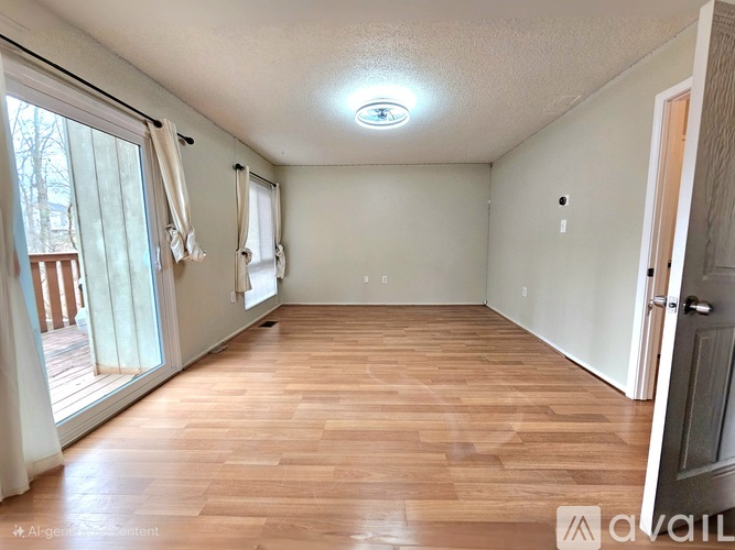 A room with wooden flooring and a ceiling light fixture.