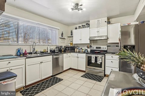 A kitchen with white cabinets and stainless steel appliances.