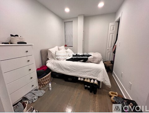 A bedroom with a bed, dresser, and suitcase.