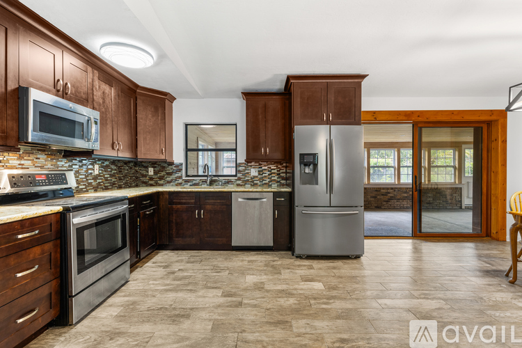 A kitchen with wooden cabinets and a stone backsplash.