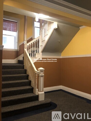 A staircase with a carpeted floor and a wooden banister.