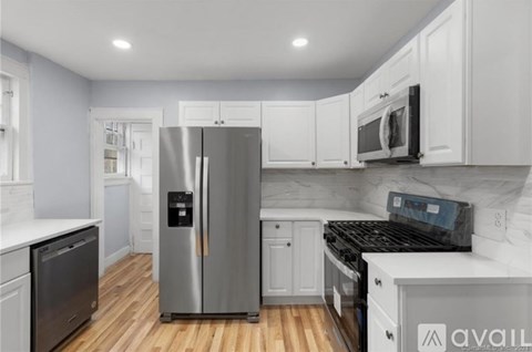 A kitchen with a stainless steel refrigerator and black appliances.