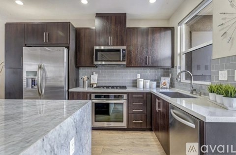 A kitchen with dark wood cabinets and stainless steel appliances.