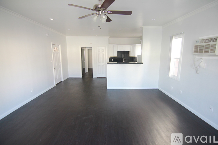 A room with wooden flooring and a ceiling fan.