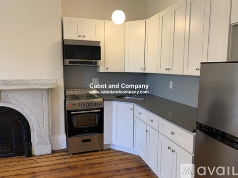A kitchen with white cabinets and a stainless steel refrigerator.