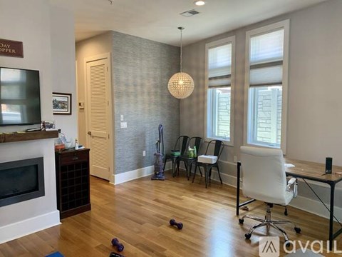 A living room with a fireplace and a dining table with chairs.