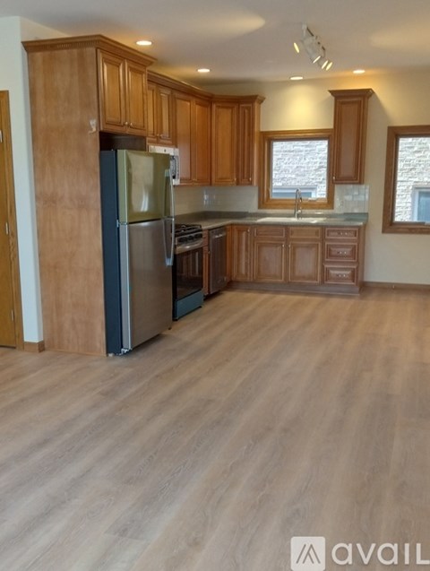 A kitchen with wooden cabinets and a refrigerator.