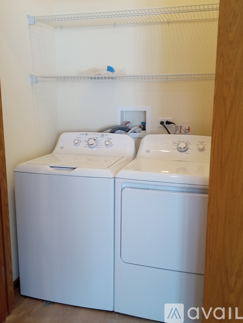 A white front loading washing machine in a small laundry room.