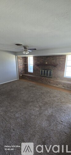 A room with a ceiling fan and a window with bars.