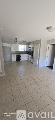 A kitchen with white cabinets and a tiled floor.