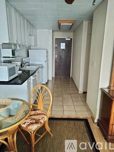 A kitchen with a table and chairs in the foreground.