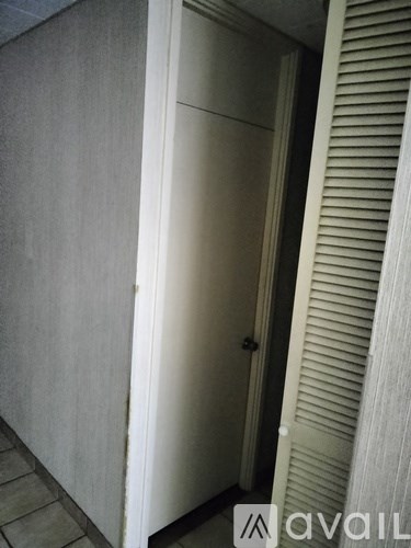 A white door is in a room with a grey wall.