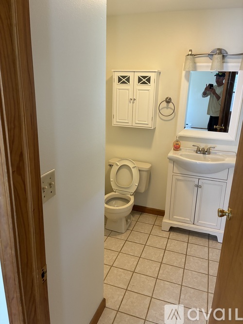 A bathroom with a toilet, sink, and medicine cabinet.