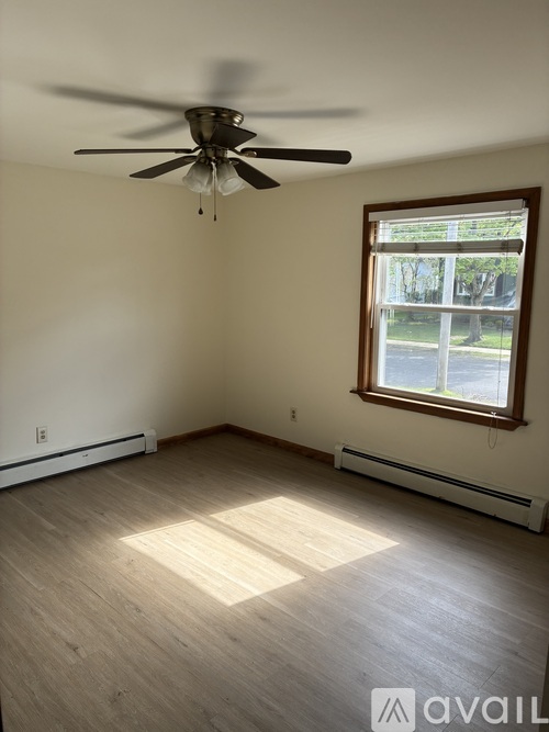 A room with a ceiling fan and a window.