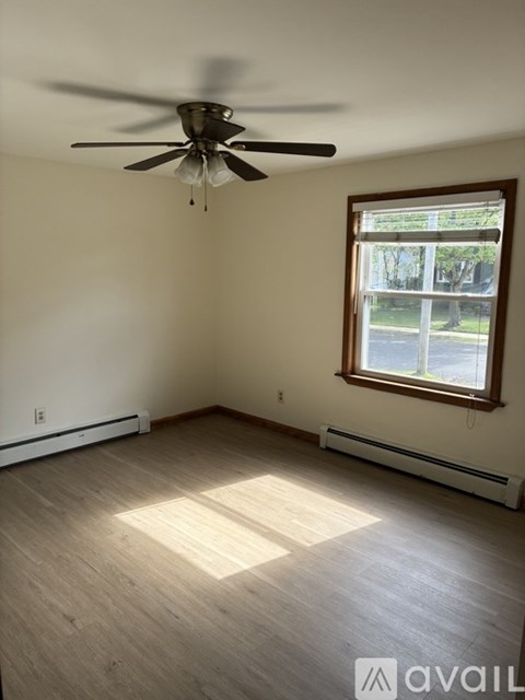 A room with a ceiling fan and a window.