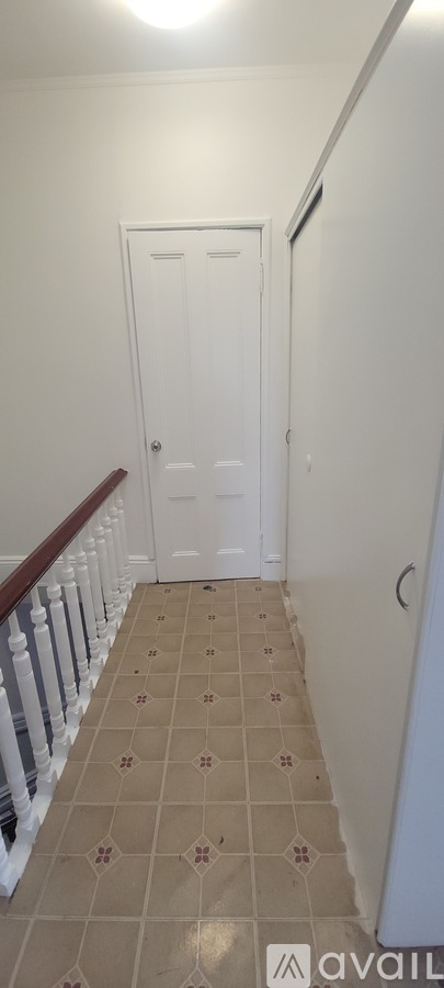 A hallway with a green door and pictures on the wall.