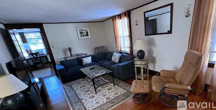 A living room with a blue couch, a chair, and a coffee table.