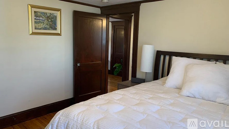 A bedroom with a large bed and a painting on the wall.