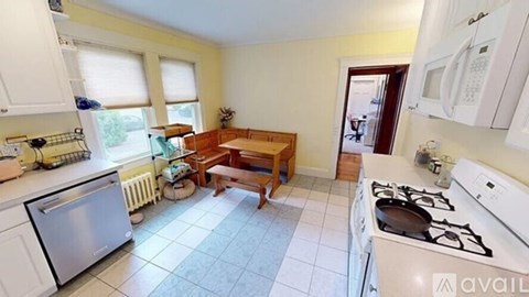 A kitchen with white appliances and a wooden table.