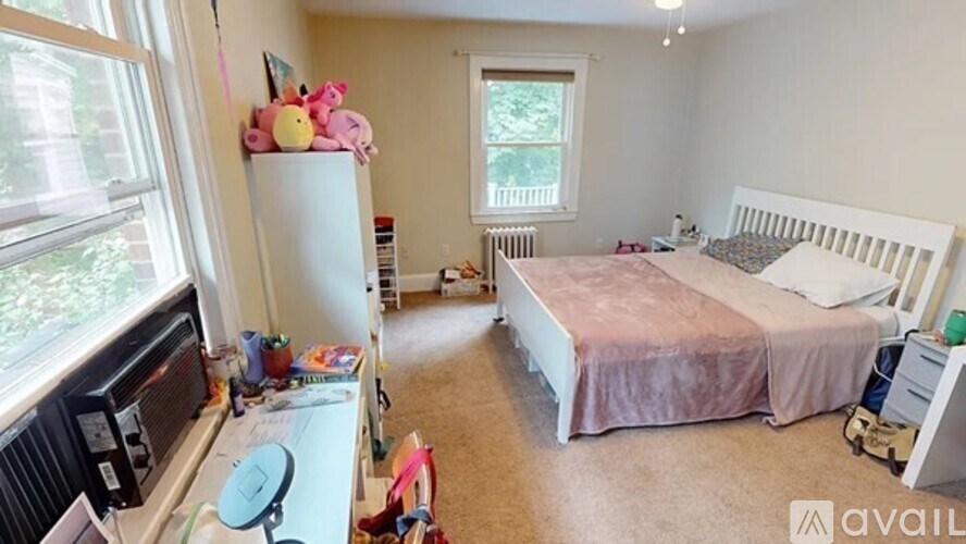 A bedroom with a bed, dresser, and window.