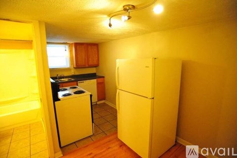 A small kitchen with a white refrigerator and a black stove top oven.