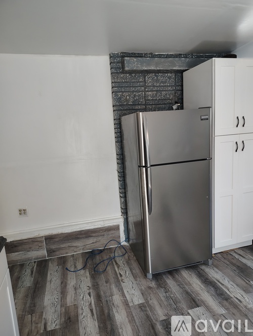 A kitchen with a stainless steel refrigerator and cabinets.