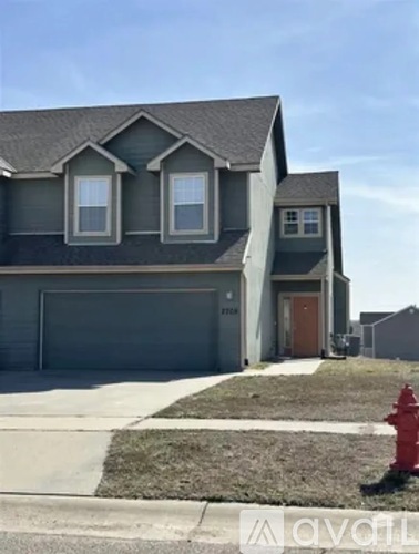 A house with a grey roof and a red fire hydrant in front.