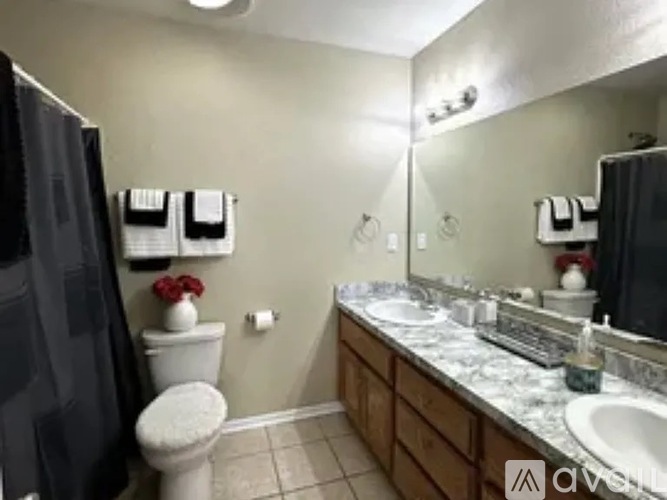 A bathroom with a toilet, sink, and mirror.