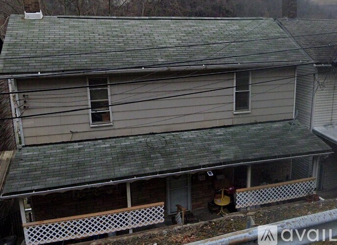 A house with a grey roof and a white fence.