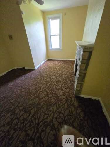 A room with a carpeted floor and a window.