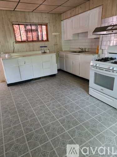 A kitchen with white appliances and a patterned floor.