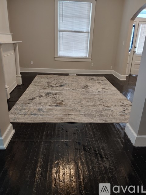 A room with a rug and wooden floors.
