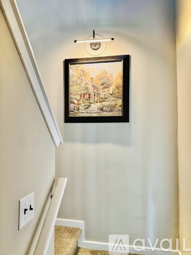A painting hangs on a wall above a staircase.