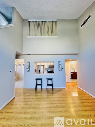 A kitchen area with a bar stool and a counter.
